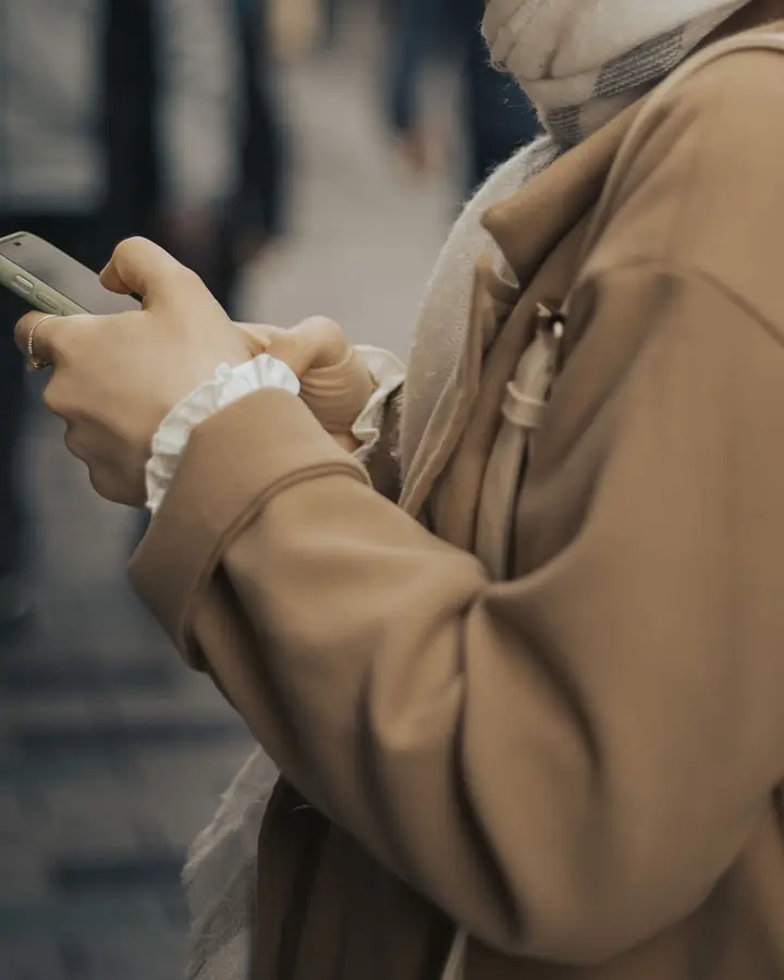 Symbolbild: Person mit Smartphone unterwegs, auf der Suche nach einem Betrieb in der Nähe